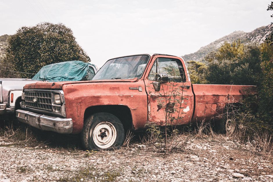 Explore the charm of a rustic, abandoned Chevrolet pickup amidst an overgrown outdoor backdrop.